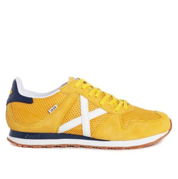 Zapatillas de la marca Munich, modelo Massana 477 en color amarillo. Zapatilla deportiva de nylon y pieza en el talón bicolor. Contraste de materiales en color amarillo con detalles en marino y blanco. Cordonera con ocho pasados con logo grabado en la talonera. El “1939” en la etiqueta lateral le añade un toque tradicional.