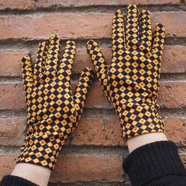 Guantes con acabado de terciopelo con estampado de geométrico en mostaza y negro. De tejido elástico para adaptarse a la mano. Perfectos para mantener las manos calientes este invierno.